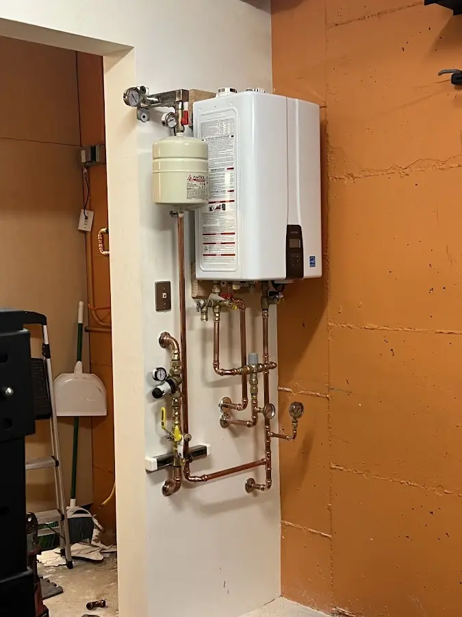 Plumbing technician inspecting water heater connections in Citronelle